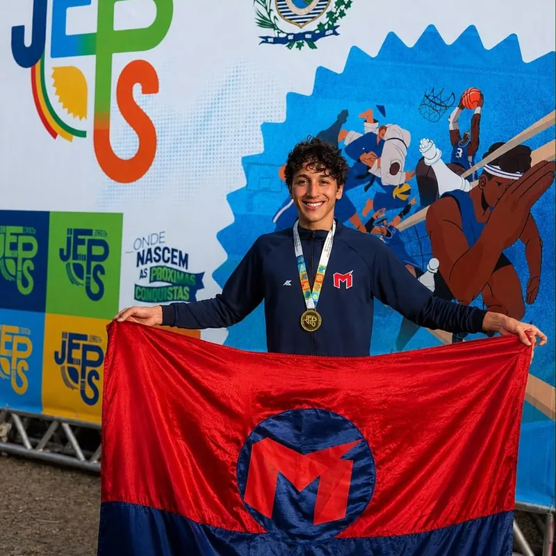 Aluno medalhista segura a bandeira do colégio nos Jogos Escolares de Pernambuco de 2026