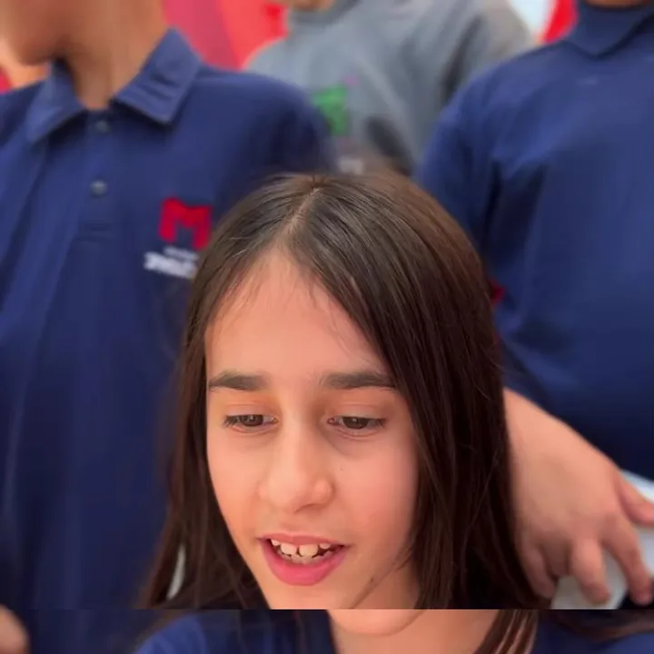 Aluna do 6º ano com a camisa do colégio, entre colegas