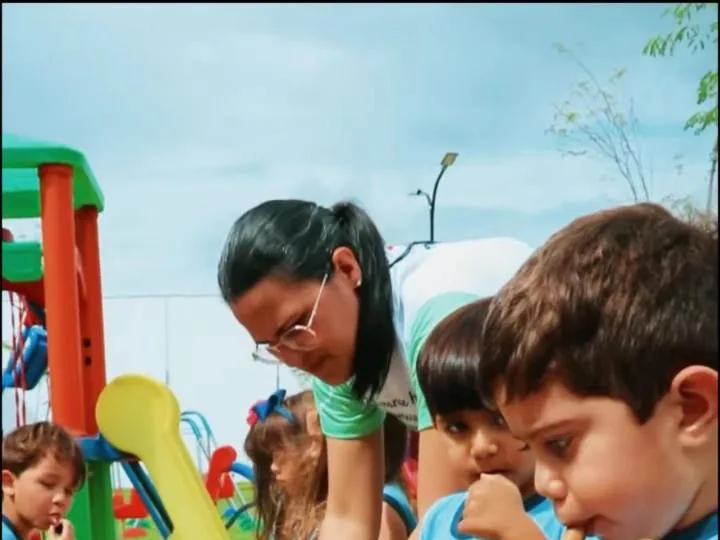 Crianças da Educação Infantil modelam argila no parquinho, com a professora