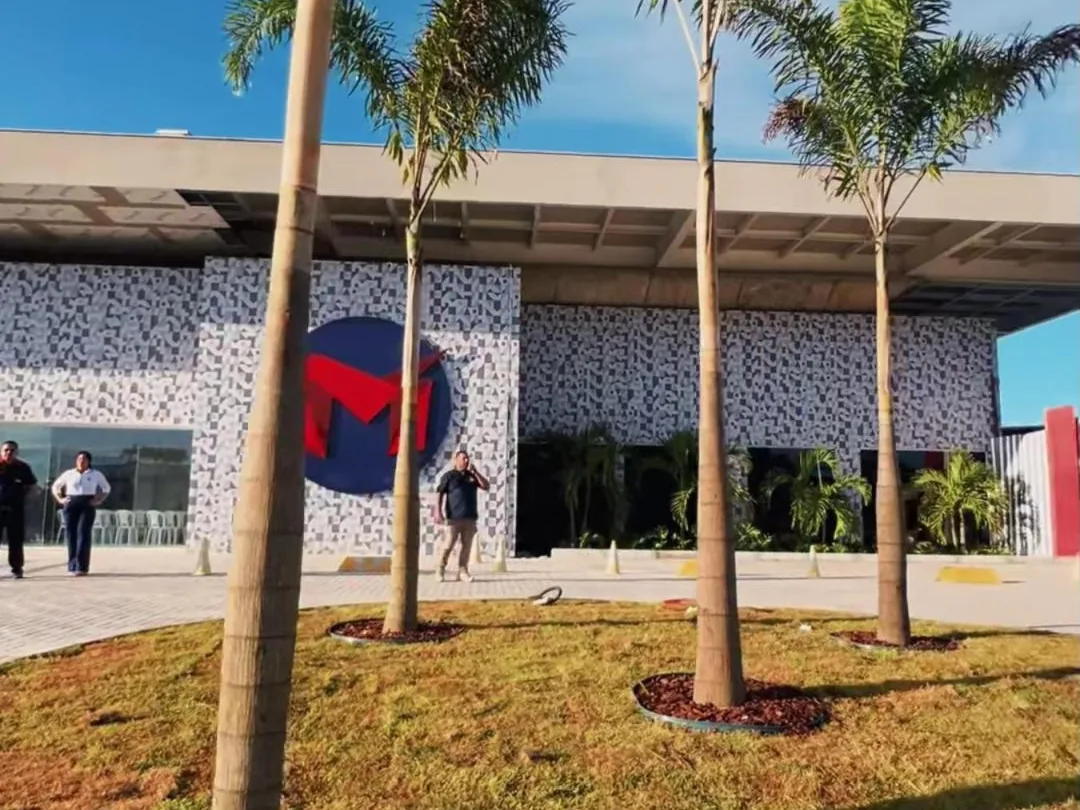 Fachada do campus novo, com as palmeiras e o M na parede